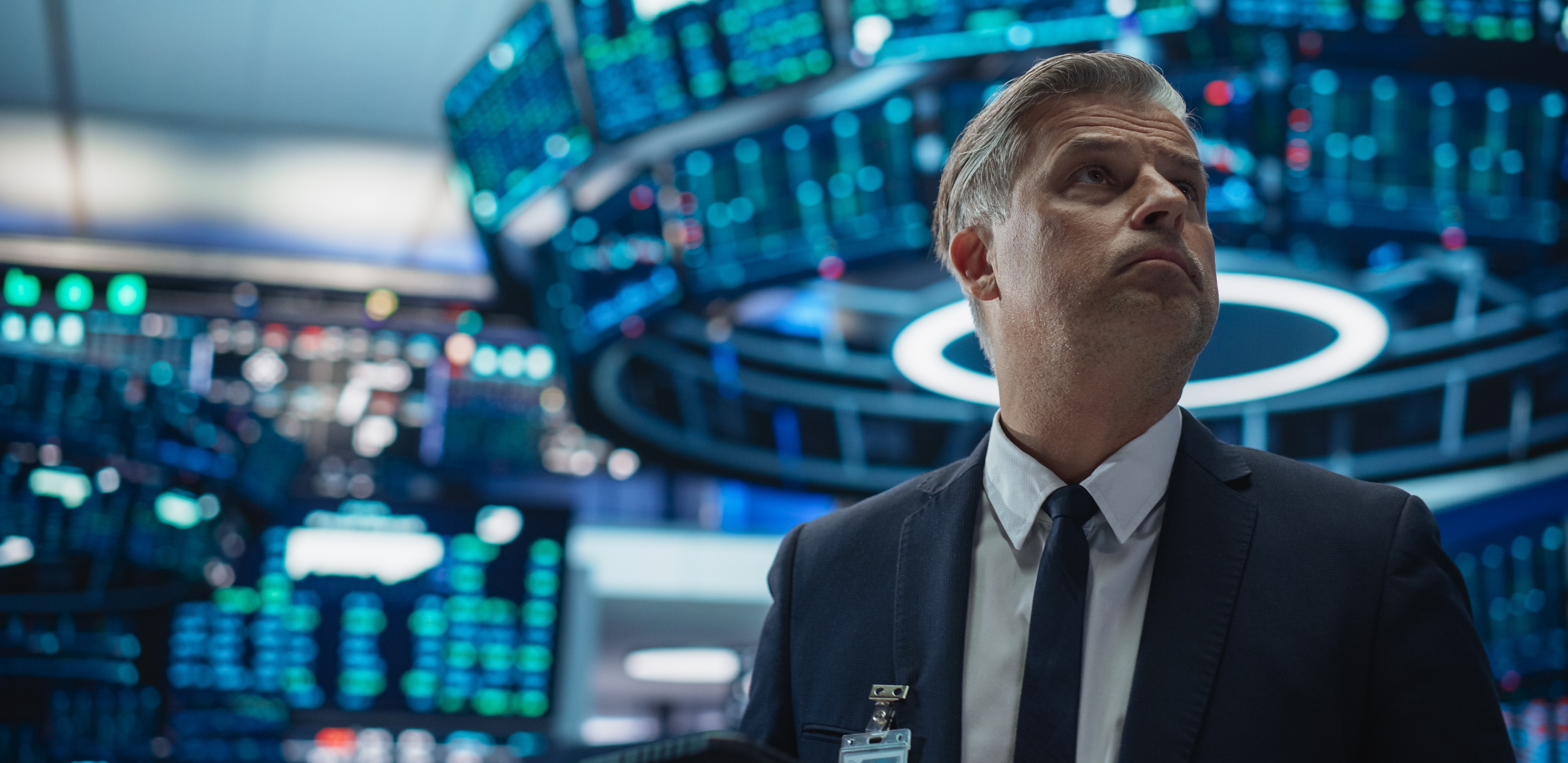 A trader looks up at financial data on a screen