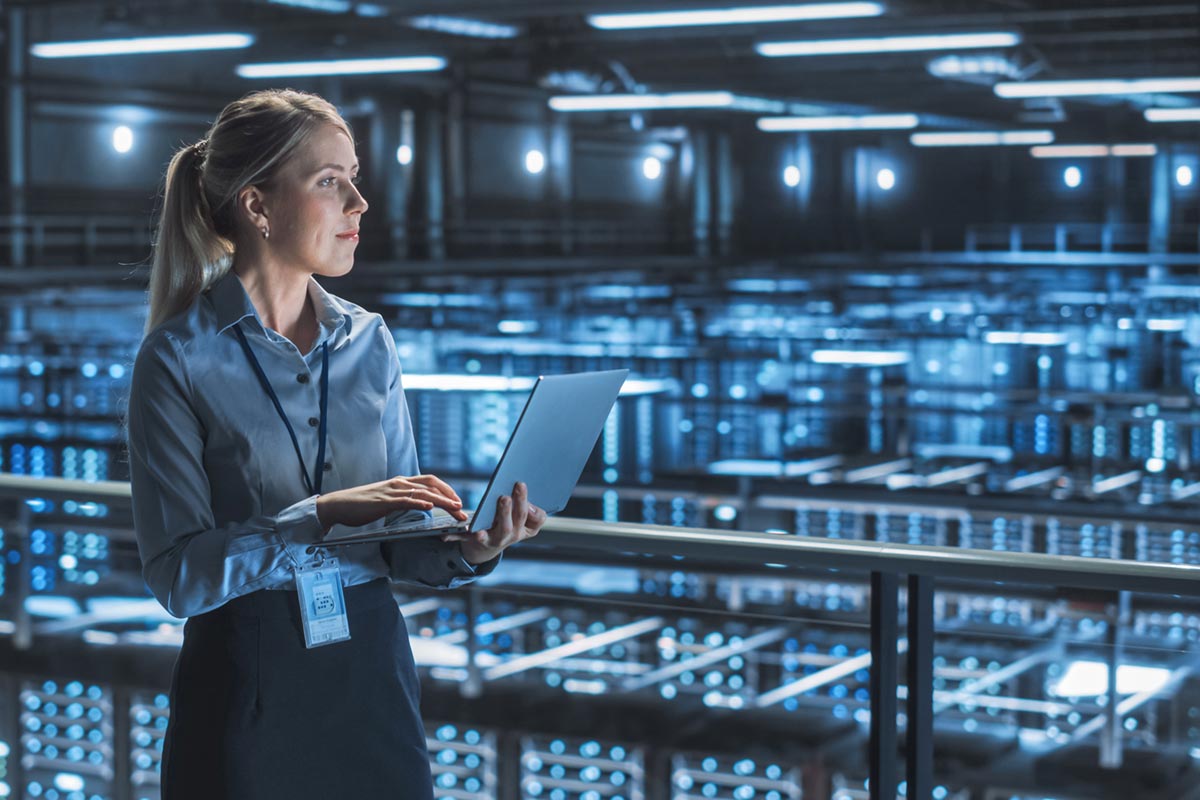 An engineer working on a laptop computer in a data center