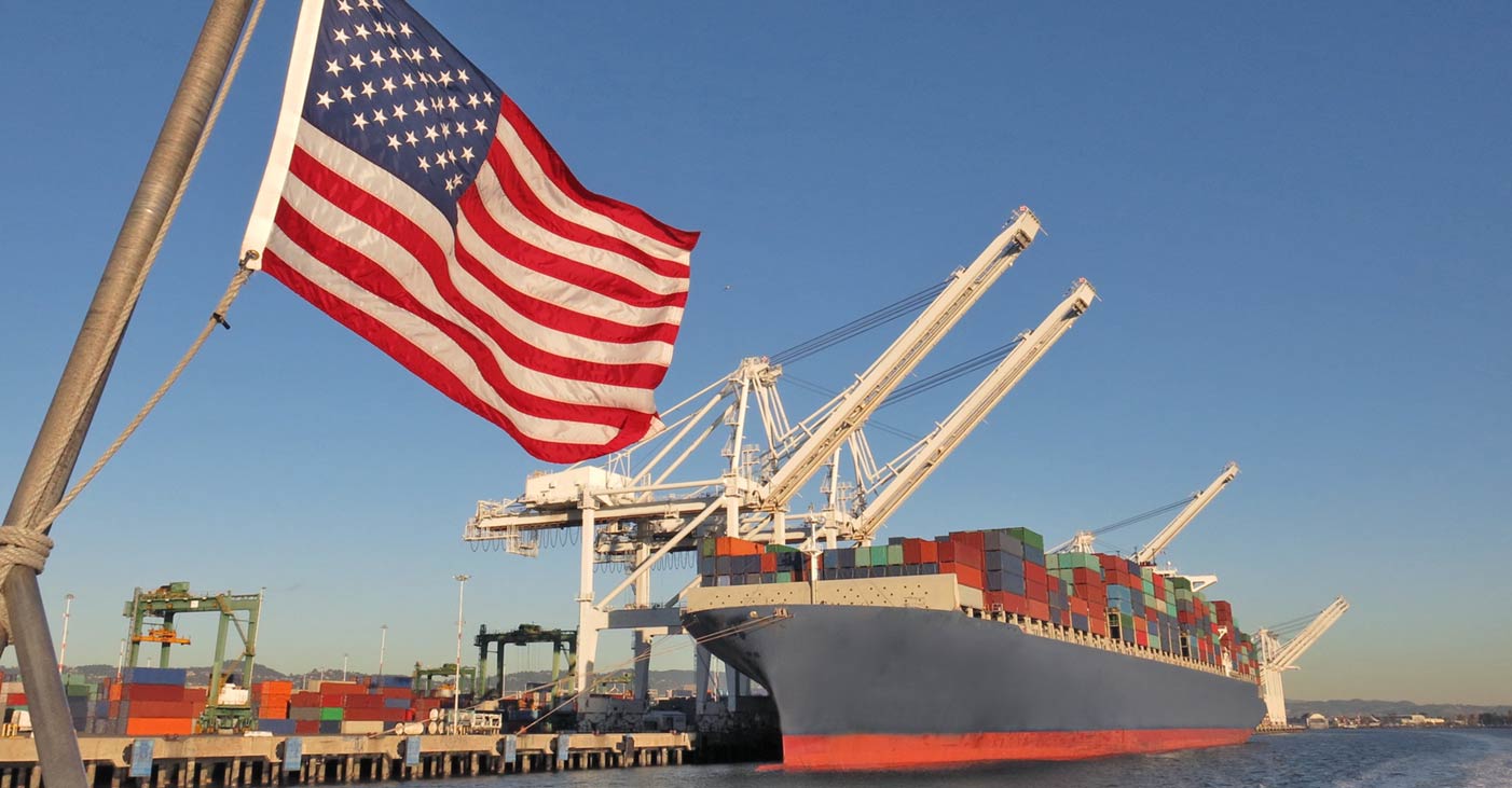 US flag and cargo ship in a container port